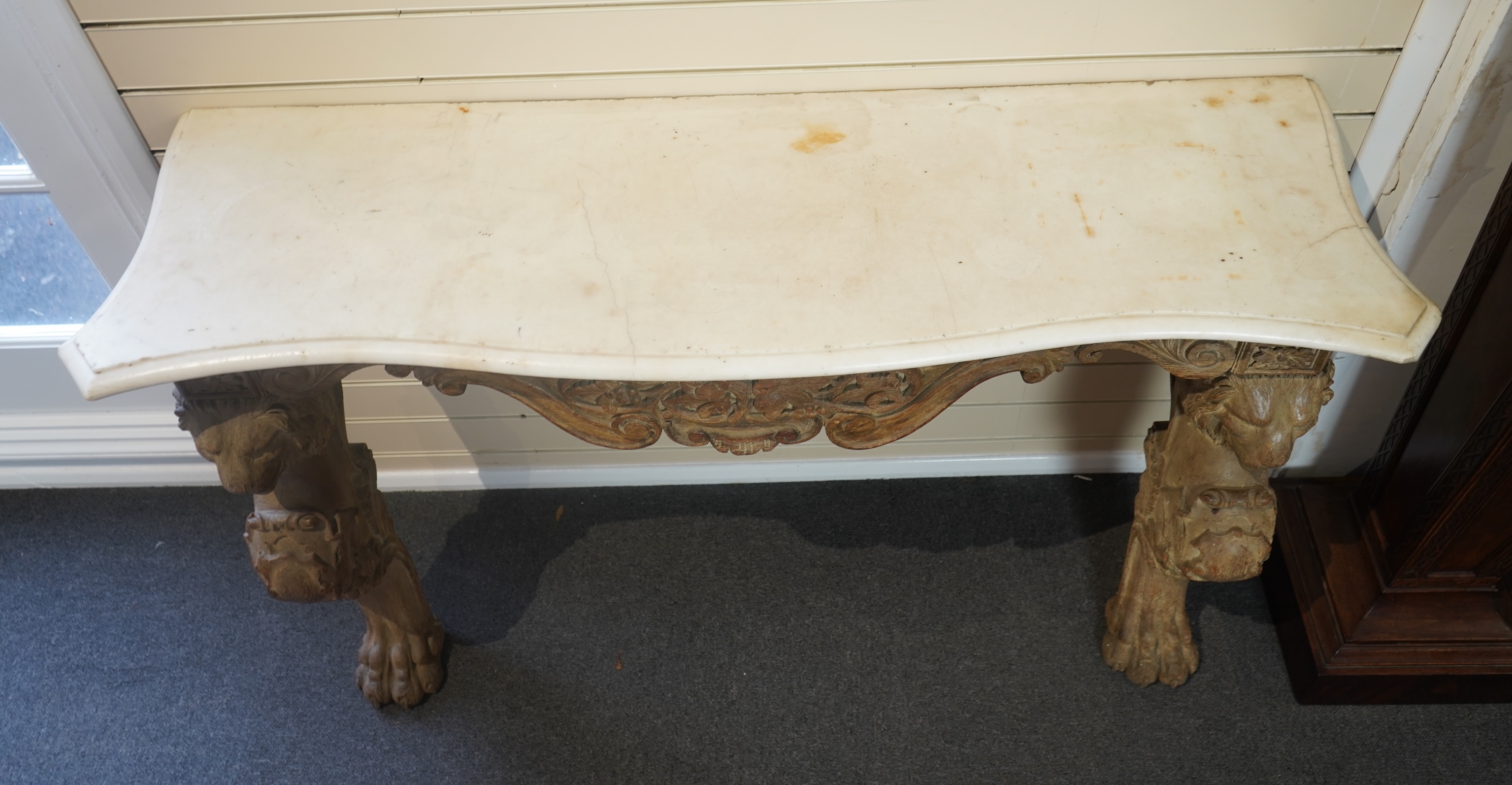 A 19th century Baroque style marble topped limed oak serpentine console table